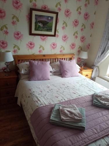 a bedroom with a bed with pink flowers on the wall at The Guest House in Abergavenny