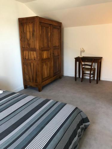 a bedroom with a wooden cabinet and a table at T3 LUC-LA-PRIMAUBE chez Monique 2 nuits minimum in Luc