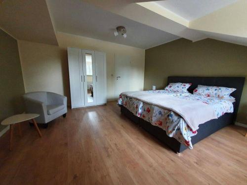 a bedroom with a large bed and a wooden floor at Ferienwohnung Am Bahnhof in Hasselfelde