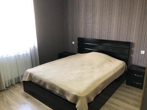 a bedroom with a bed with a black headboard at Katerina in Bakuriani