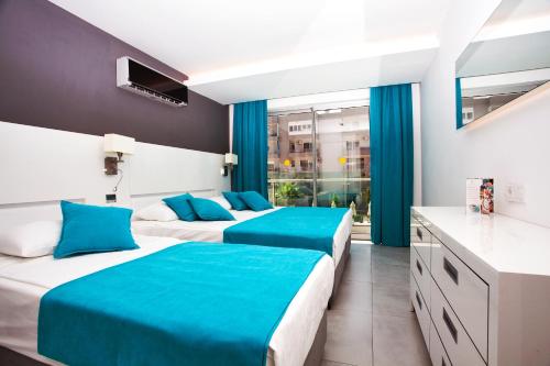 2 camas en una habitación de hotel con sábanas azules en Green Garden Suites Hotel, en Alanya