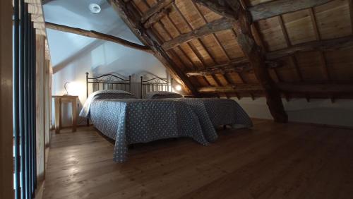 ein Schlafzimmer mit einem Bett in einem Zimmer mit Holzböden in der Unterkunft Agriturismo Casa Marietta in Tremea