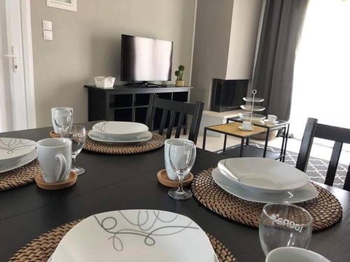 a dining room table with plates and glasses on it at Town House - Ocean View in Nikiti