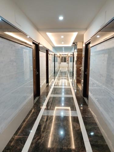 a hallway in a building with a tile floor at Nagas Inn by Unicorn in Krishnagiri