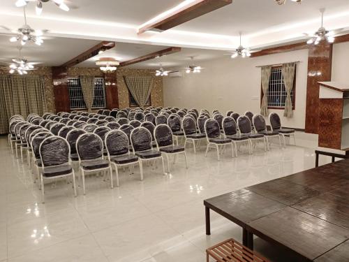 a large room with chairs and tables in it at Nagas Inn by Unicorn in Krishnagiri