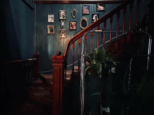 a hallway with a staircase with pictures on the wall at Auberge Du Bon Yeu in Saint-Siméon