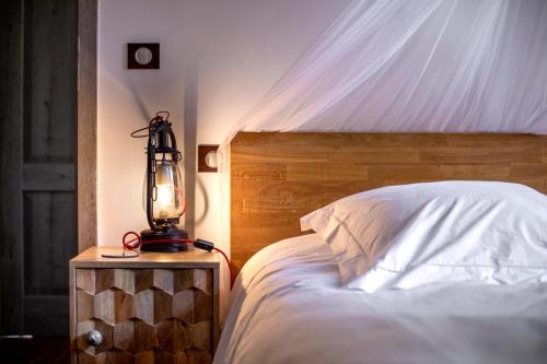 a bedroom with a bed with a lamp on a night stand at Le Mas des Romarins, FAYENCE in Fayence