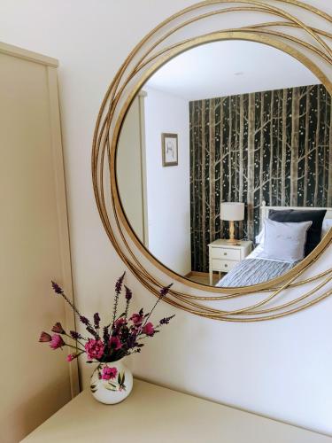 a bedroom with a large mirror on the wall at Furlong Cottage @ Higher Stancombe Farm in Kingsbridge