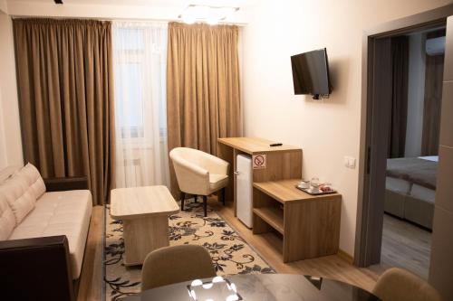 a room with a living room with a couch and a bed at Lotus Hotel Chisinau in Chişinău