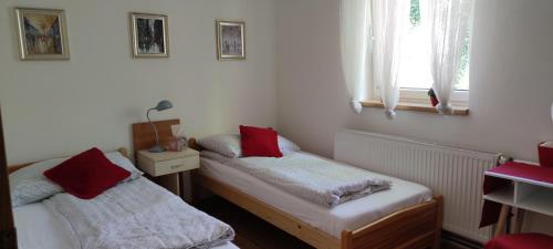 um quarto com 2 camas individuais e almofadas vermelhas em JUDIA em Litomyšl