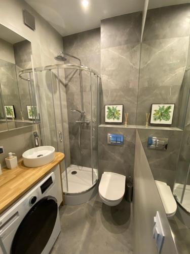y baño con ducha, aseo y lavamanos. en Brand New apartment in perfect location en Varsovia