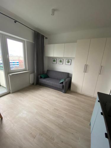 sala de estar con sofá y ventana grande en Brand New apartment in perfect location, en Varsovia