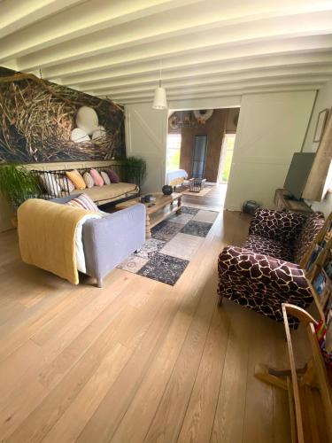 a large living room with a couch and a chair at Le Nid Douillet in Theux