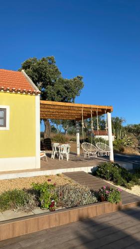 a patio with a table and chairs and a pergola at Celestial Melides Country House in Melides