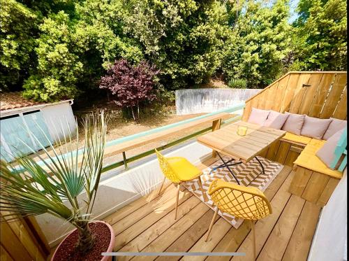 une terrasse en bois avec une table et des chaises dessus dans l'établissement Front de mer Rivedoux-Plage - Terrasse Extérieur - Parking, à Rivedoux-Plage