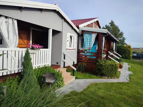 Casa blanca con porche y patio en Domki letniskowe Eliza, en Chłopy
