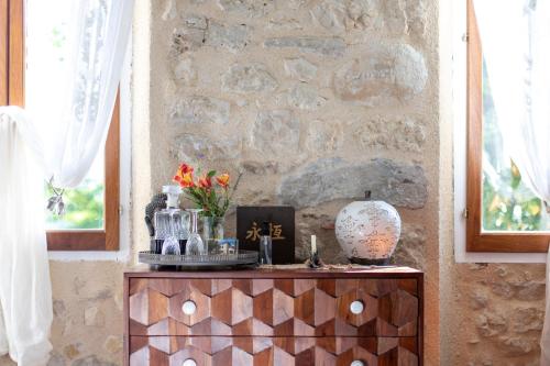 a table in a room with a stone wall at Le Mas des Romarins, FAYENCE in Fayence