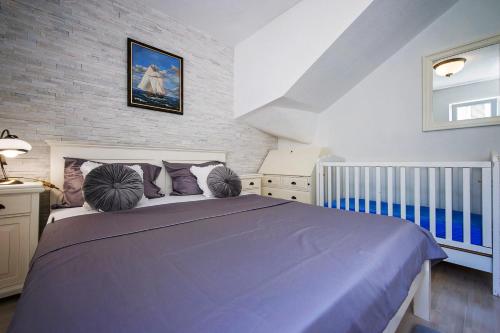 a bedroom with a large blue bed with pillows at Casa del Mare in Rogoznica