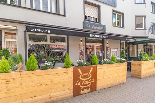 a store front of a building with a wooden fence at Esplanade Hotel in Diekirch