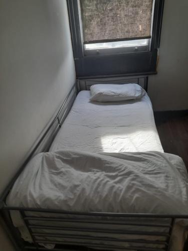 2 camas en una habitación pequeña con ventana en Woolwich Backpackers New, en Woolwich