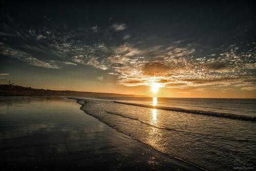 a sunset on a beach with the sun setting at 45 Grande Rue bis in Ault