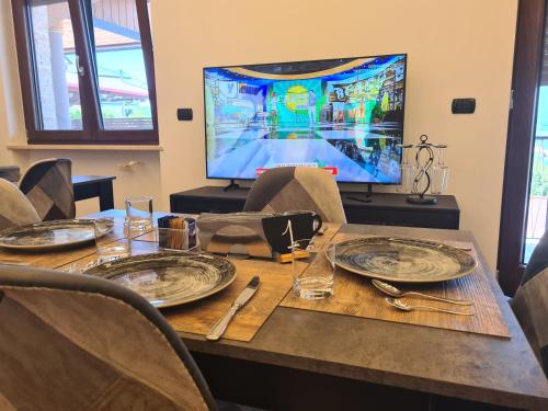 a dining room table with a television in the background at Rossi&Nero Resort - servizi extra a pagamento Ristorante Piscina Sauna Spa in Pasquarelli