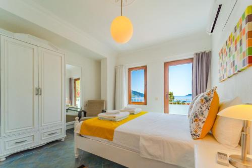 a white bedroom with a bed and a window at Pier Rooms & Pansiyon in Kalkan