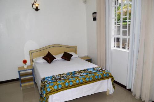 1 dormitorio con cama, ventana y puerta en MauriSoleil Villa Privée avec Piscine - Flic en Flac, en Flic en Flac