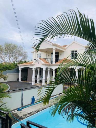 a white house with a swimming pool in front of it at MauriSoleil Villa Privée avec Piscine - Flic en Flac in Flic-en-Flac