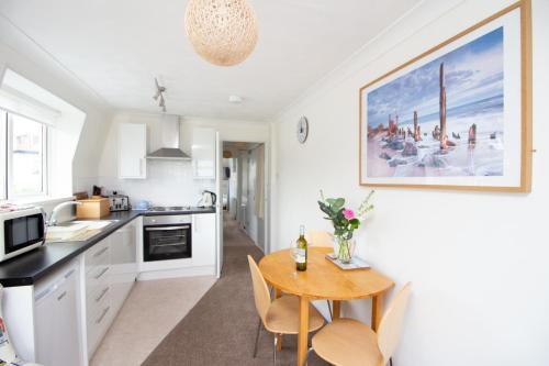 a kitchen with a table and chairs in a room at Three Beaches Holiday Apartments - close to Goodrington beach in Paignton in Paignton