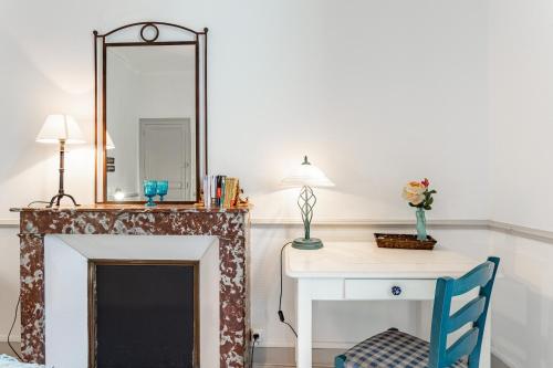 a room with a fireplace and a desk with a mirror at Ker Cobi in Dinard