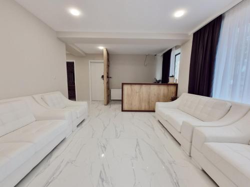 a white living room with two white couches at Picasso in Shekvetili