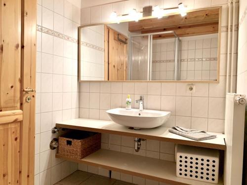 a bathroom with a sink and a mirror at Ferienwohnung 3 im Böhler Haubarg in Sankt Peter-Ording