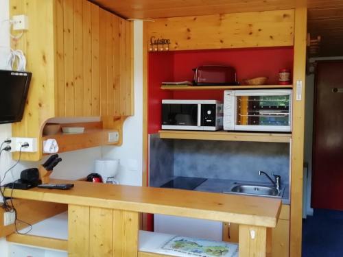 une petite cuisine avec un comptoir et un évier dans l'établissement Duplex 2 pièces 5 pers, balcon sud, proche pistes et commerces, Animaux admis - Arc 1800 - FR-1-411-296, à Arc 1800