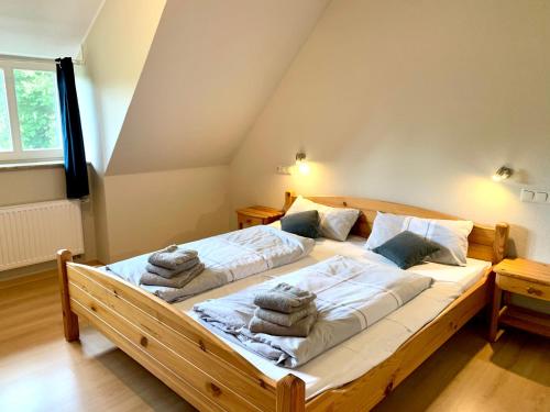una camera da letto con un grande letto in legno con asciugamani di Ferienwohnung 4 im Böhler Haubarg a Sankt Peter-Ording
