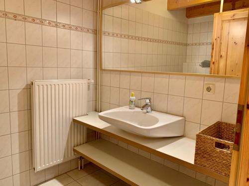 a bathroom with a sink and a mirror and a radiator at Ferienwohnung 2 im Böhler Haubarg in Sankt Peter-Ording