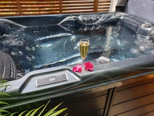 a tub with a glass of wine and a flower at Les sens ciels in Saint-Louis