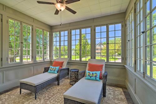 a screened in porch with chairs and windows at Sodus Point Historic Home about half Mi to Sodus Bay! in Sodus