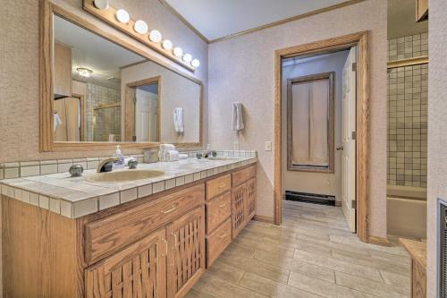 a bathroom with a sink and a large mirror at Wraparound Deck and Pool Access Truckee Cabin in Truckee