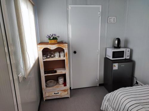 a room with a microwave and a cabinet with a refrigerator at Casita de Piedra Loft 7 - 8 - 9 in Trinidad