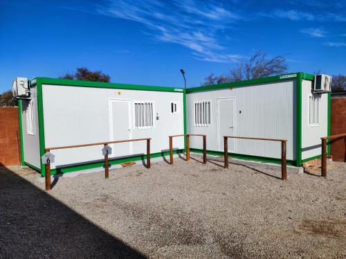 een paar witte en groene gebouwen op een parkeerplaats bij Casita de Piedra Loft 7 - 8 - 9 in Trinidad