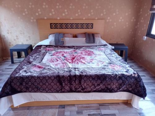 a bedroom with a bed with a quilt on it at Wadi Rum Nature Tours And Camp in Wadi Rum