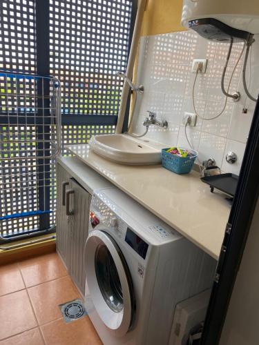 een badkamer met een wasmachine en een wastafel bij Appartement - Costa del Silencio in Costa Del Silencio