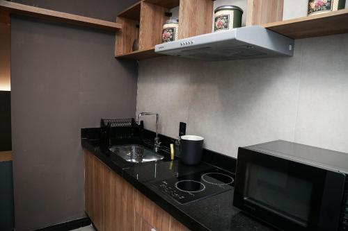 a small kitchen with a sink and a microwave at Globo Lar Studios in Limeira