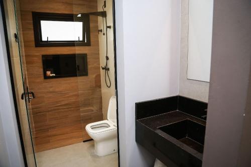 a small bathroom with a toilet and a sink at Globo Lar Studios in Limeira