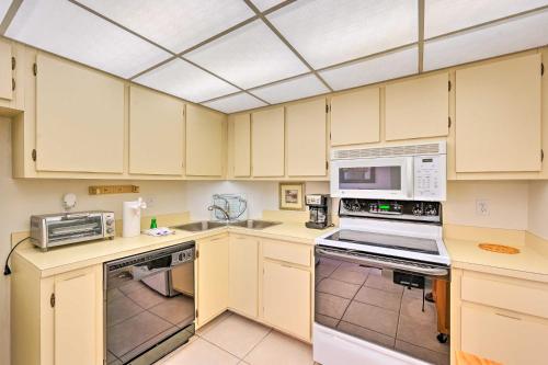 a kitchen with white cabinets and white appliances at Beachfront Marco Island Condo with Pool Access! in Marco Island