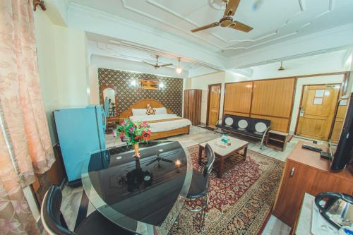 a hotel room with a bed and a living room at Hotel Priya Palace in Guwahati