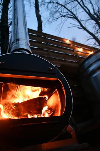 une cuisinière avec une cheminée à l'intérieur dans l'établissement Tente bivouac Option bain chauffée au bois, à Idrac-Respailles