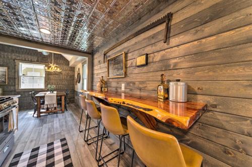 a dining room with a long wooden bar with chairs at The Reubling House - Modern-Rustic Cabin! in Defiance