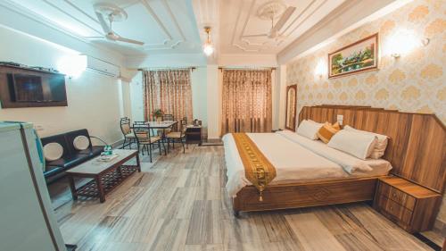 a bedroom with a large bed and a dining room at Hotel Priya Palace in Guwahati